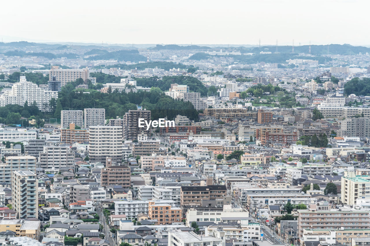 HIGH ANGLE VIEW OF CITYSCAPE AGAINST SKY