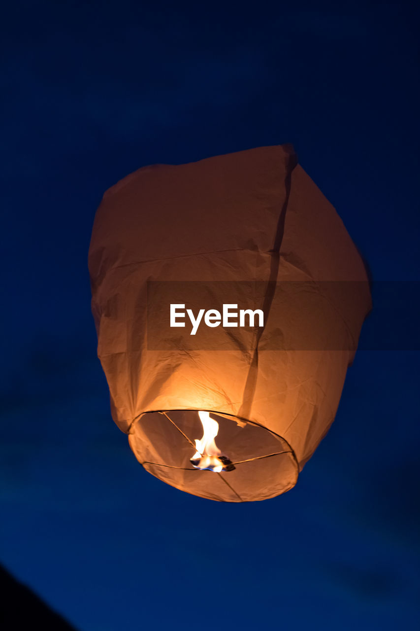 LOW ANGLE VIEW OF ILLUMINATED LANTERN AGAINST SKY