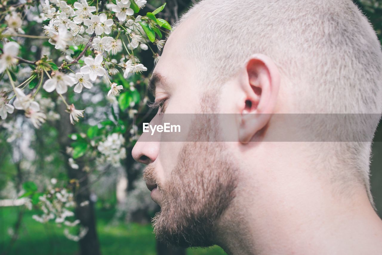 CLOSE-UP PORTRAIT OF MAN WITH FLOWER