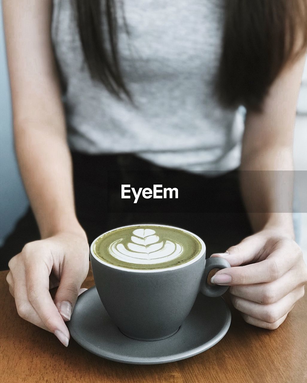 Midsection of woman holding coffee cup