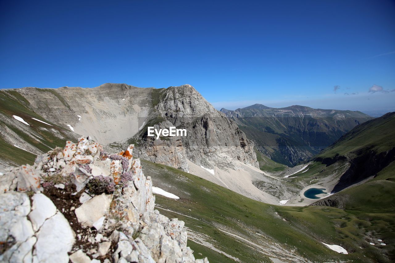 Scenic view of mountains against clear blue sky