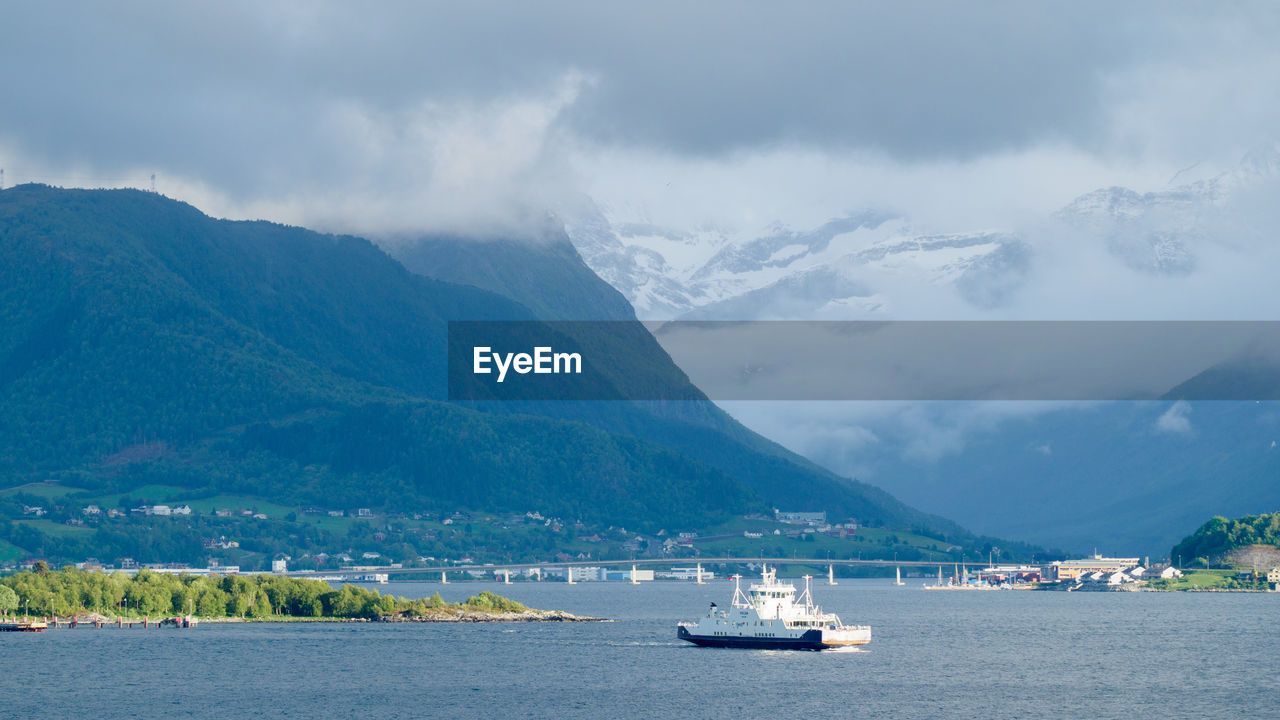 SCENIC VIEW OF BAY AGAINST MOUNTAINS