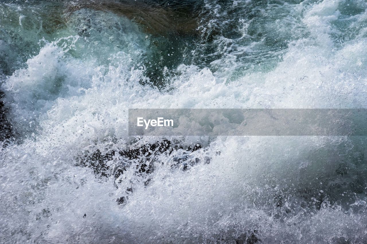 High angle view of waves splashing on rocks