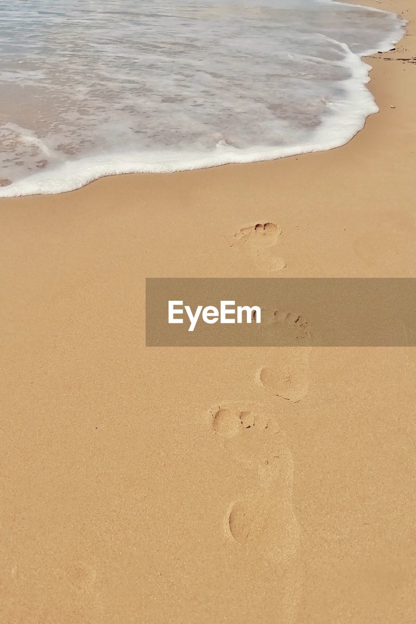 HIGH ANGLE VIEW OF FOOTPRINT ON BEACH