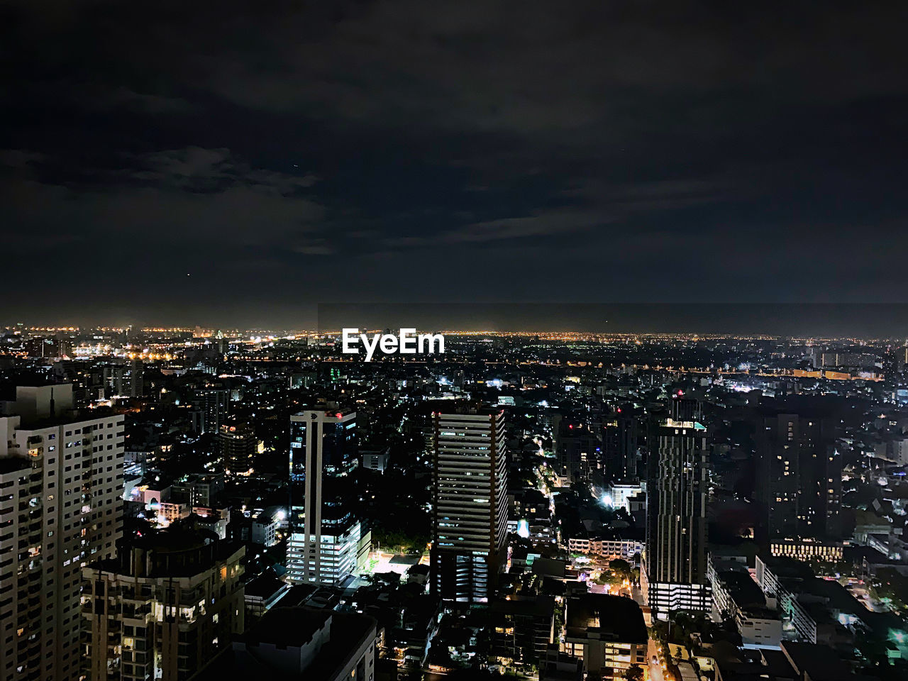 High angle view of illuminated buildings against sky at night