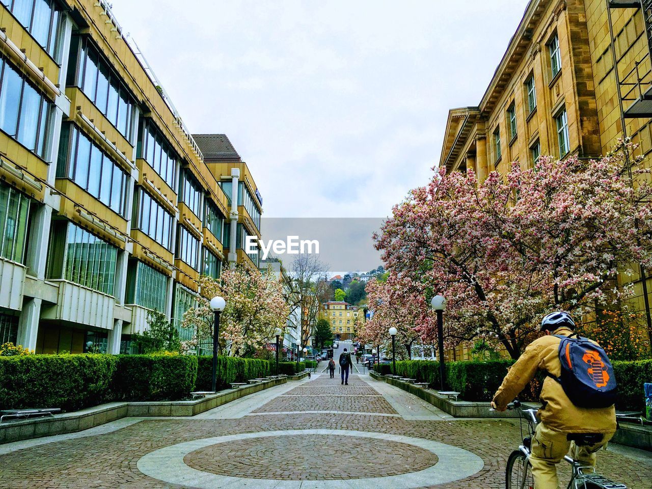 PEOPLE WALKING ON STREET AMIDST BUILDINGS