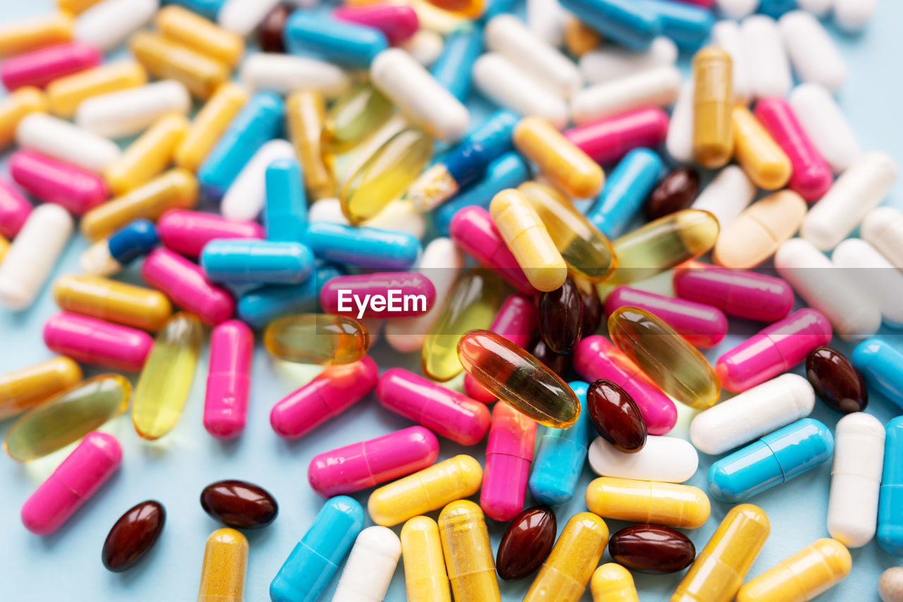 Lots of colorful pills and capsules for different symptoms. concept of health and medicine