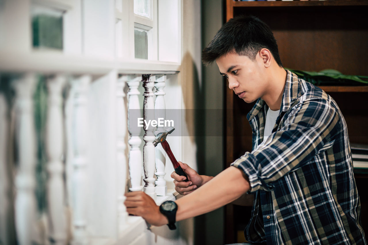 SIDE VIEW OF YOUNG MAN LOOKING AT CAMERA