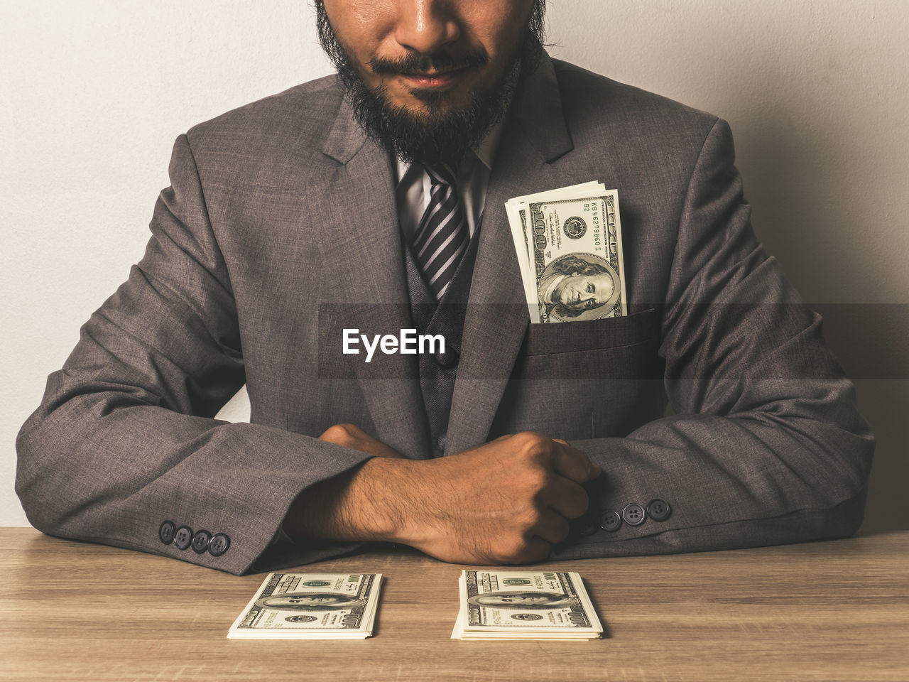 Midsection of businessman with paper currency at table