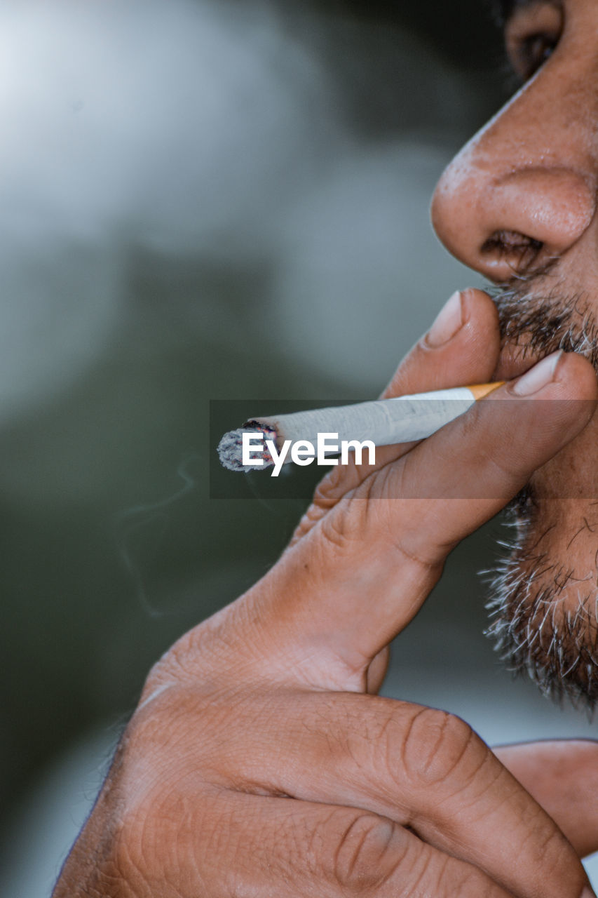 Close-up portrait of the cigarette from a man who's smoking