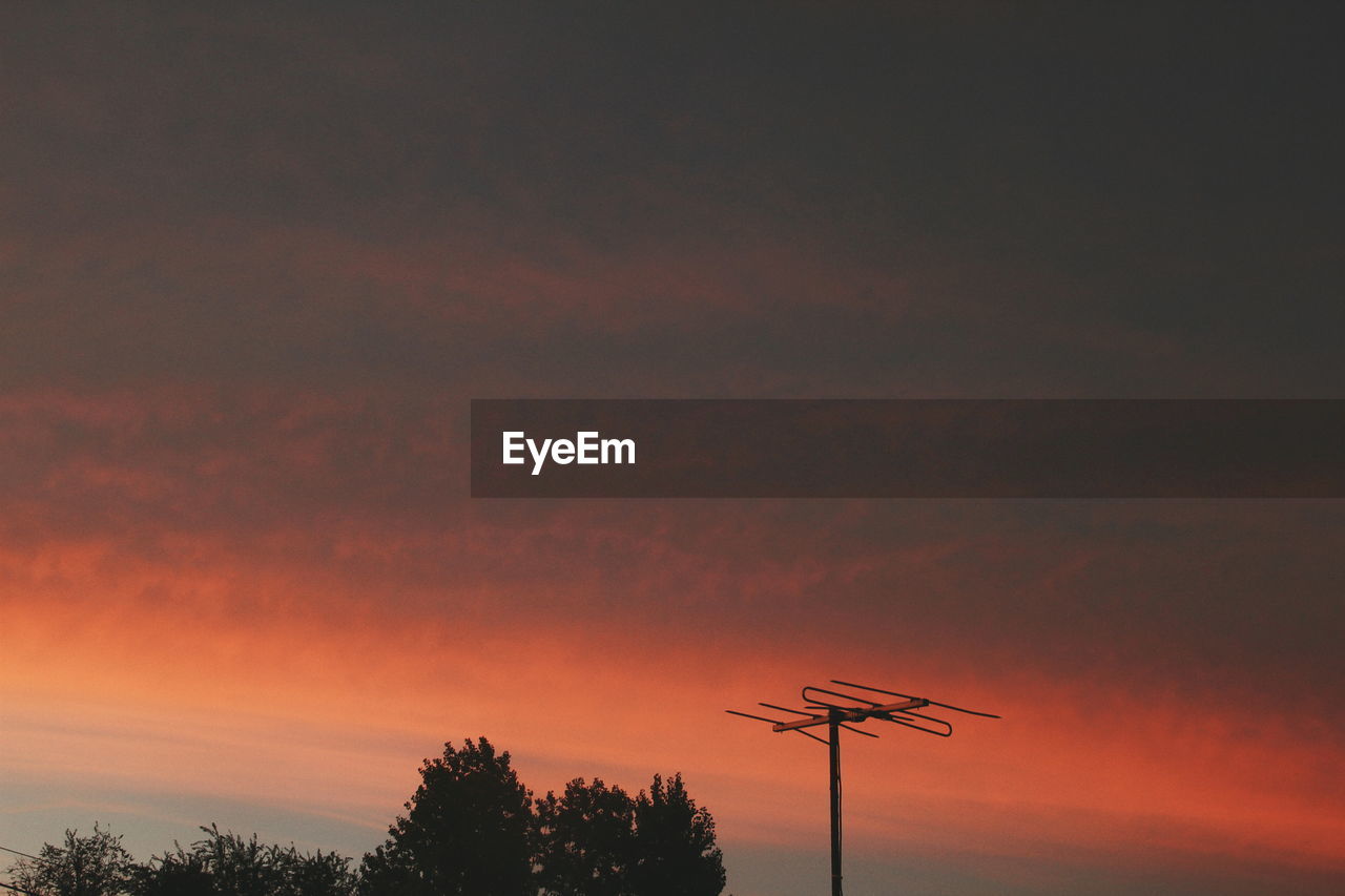 Silhouette of trees against cloudy sky