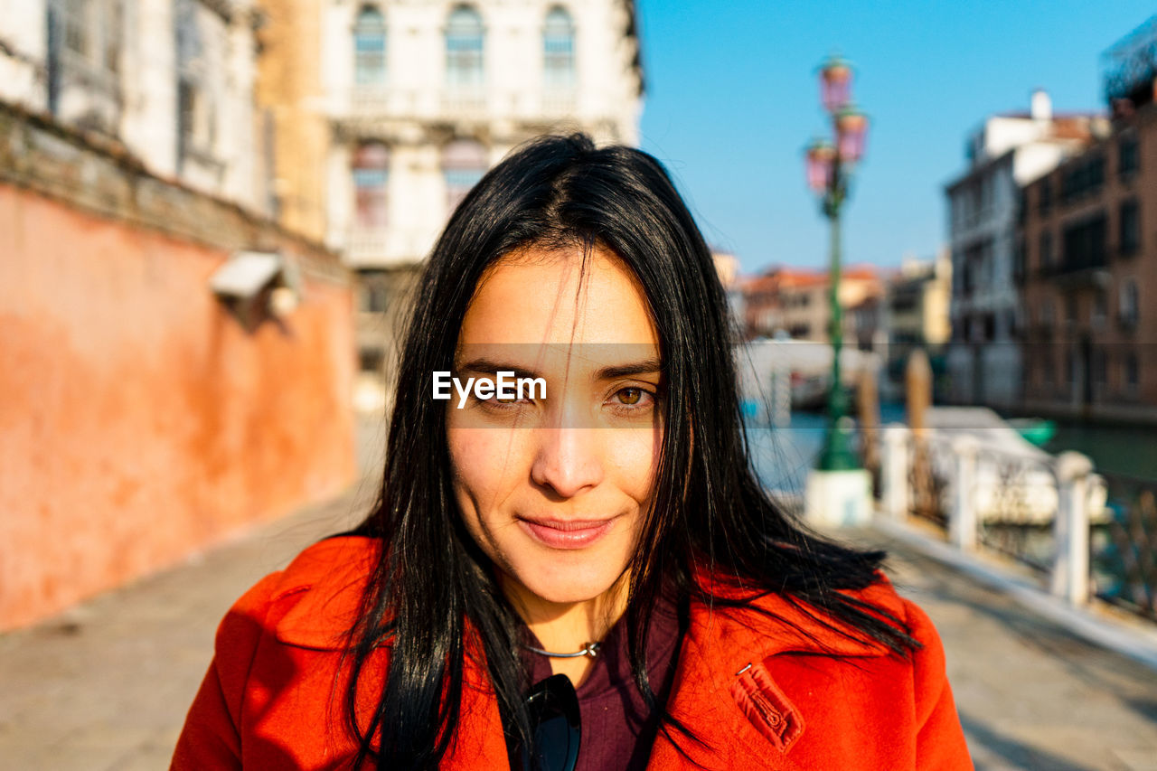 Portrait of a smiling young woman in city