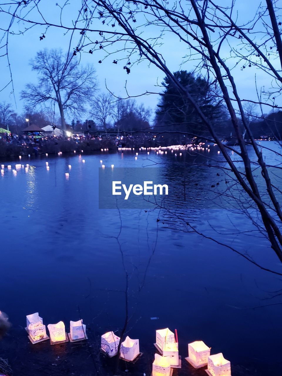 SCENIC VIEW OF LAKE AGAINST ILLUMINATED BUILDINGS AT DUSK