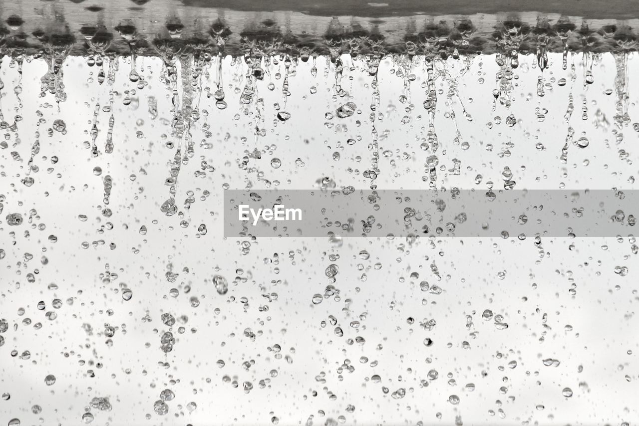 Low angle view of raindrops against sky