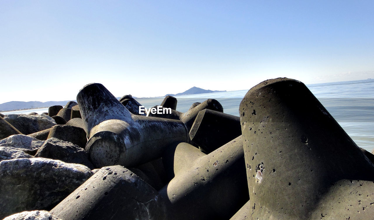 SCENIC VIEW OF ROCKS ON BEACH AGAINST CLEAR SKY