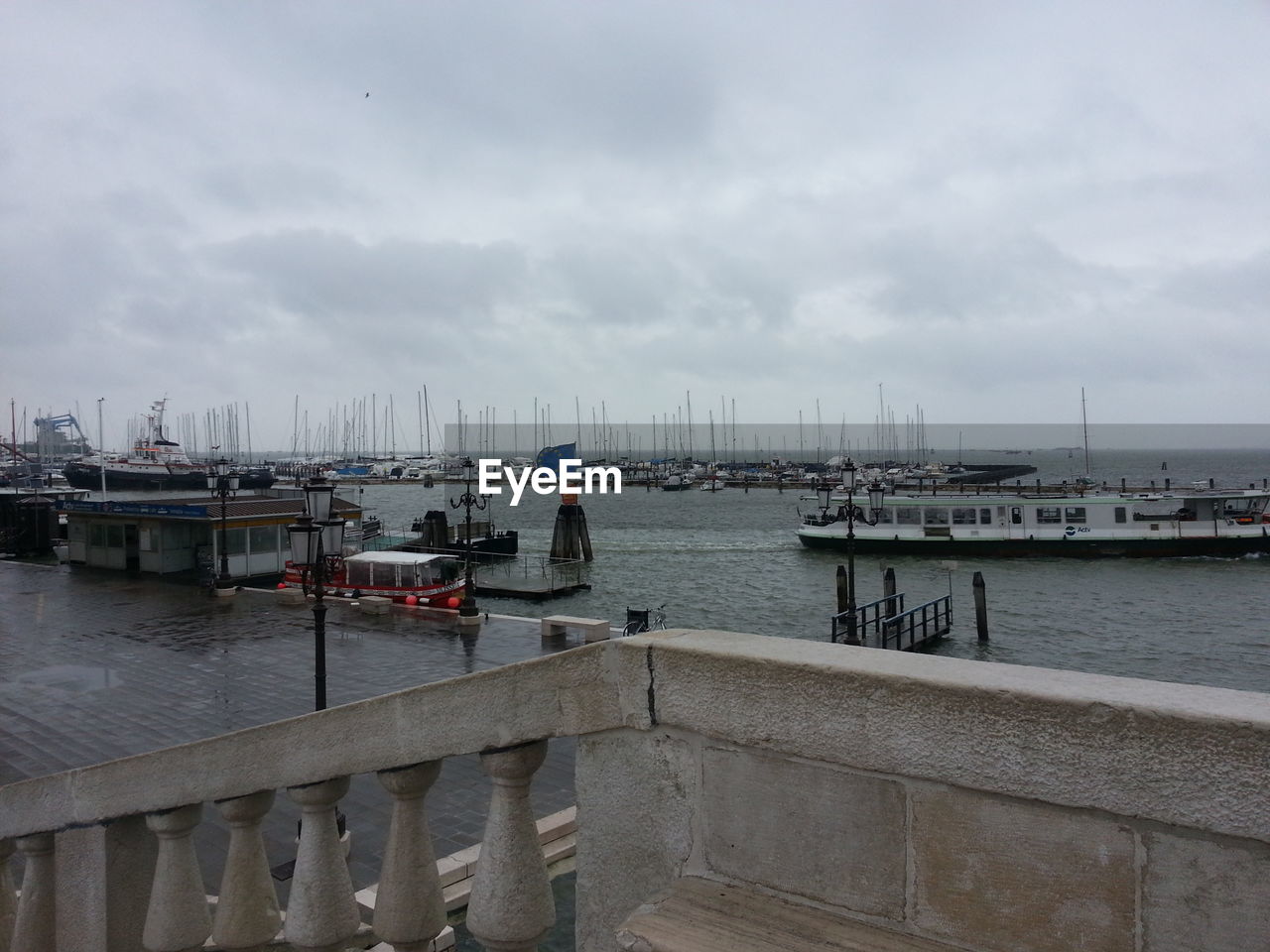 VIEW OF HARBOR AGAINST CLOUDY SKY