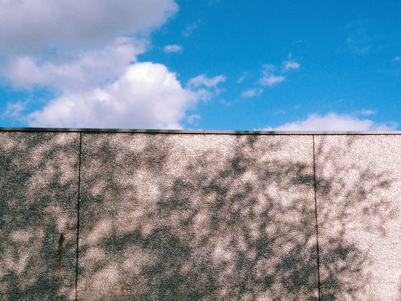 Wall against cloudy sky