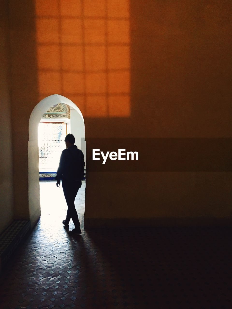 Silhouette of man walking inside building