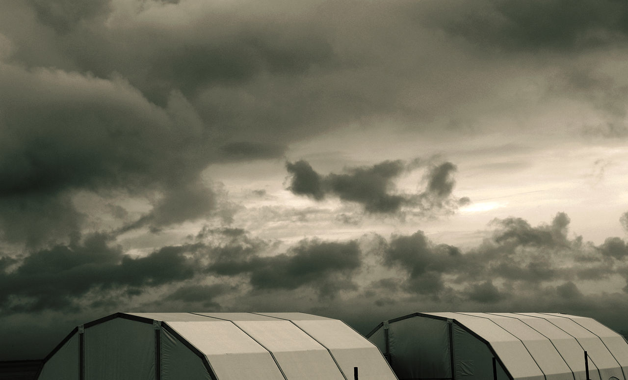 Tents against cloudy sky