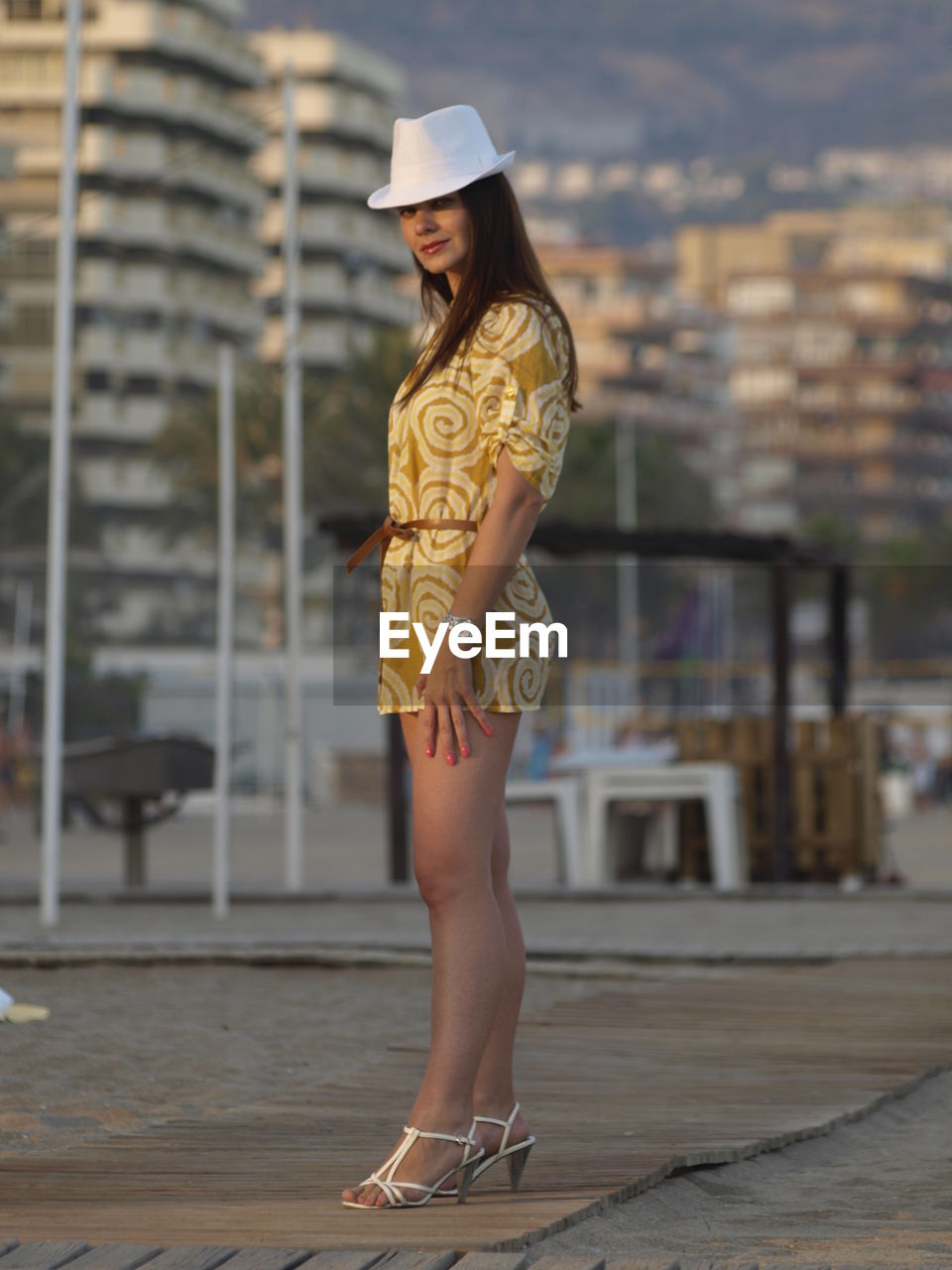 Full length of beautiful woman standing against buildings