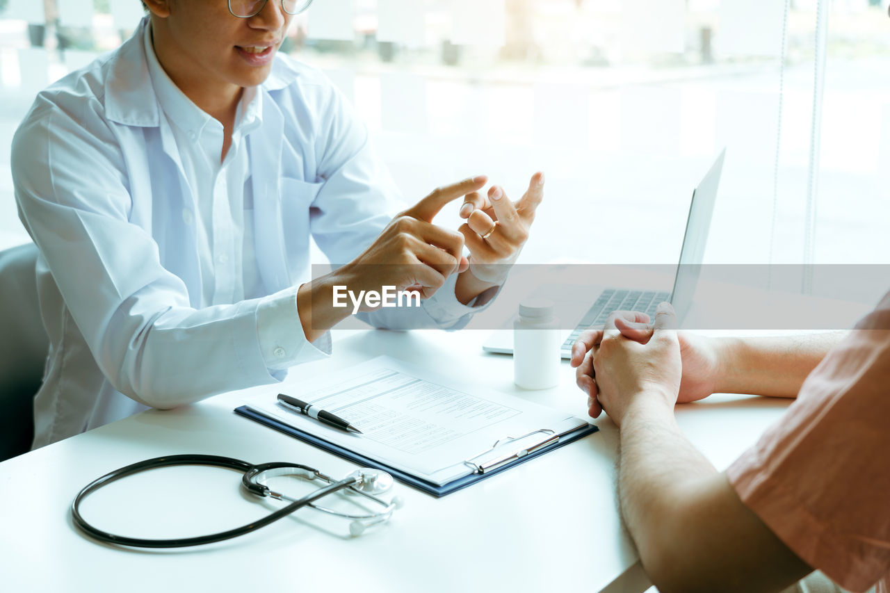 midsection of doctor examining patient in hospital