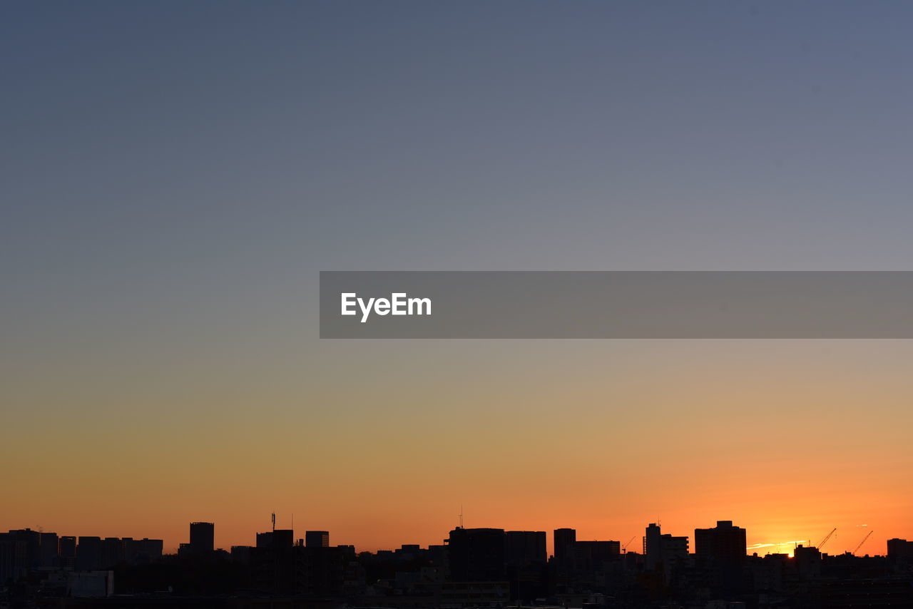 CITYSCAPE AGAINST CLEAR SKY AT SUNSET