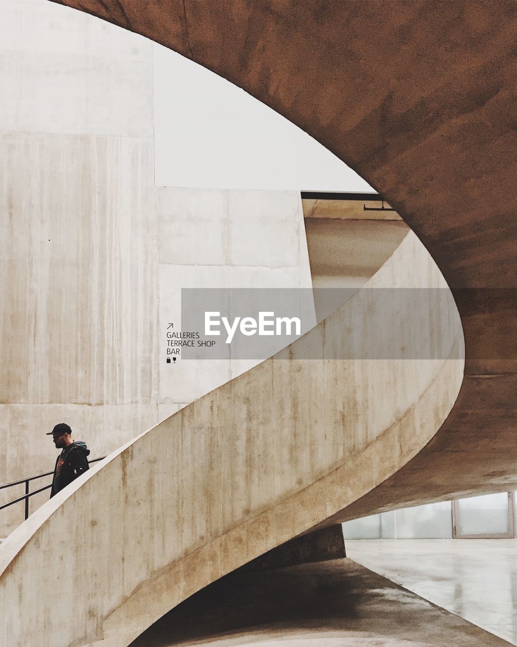 Man moving down on spiral staircase against wall