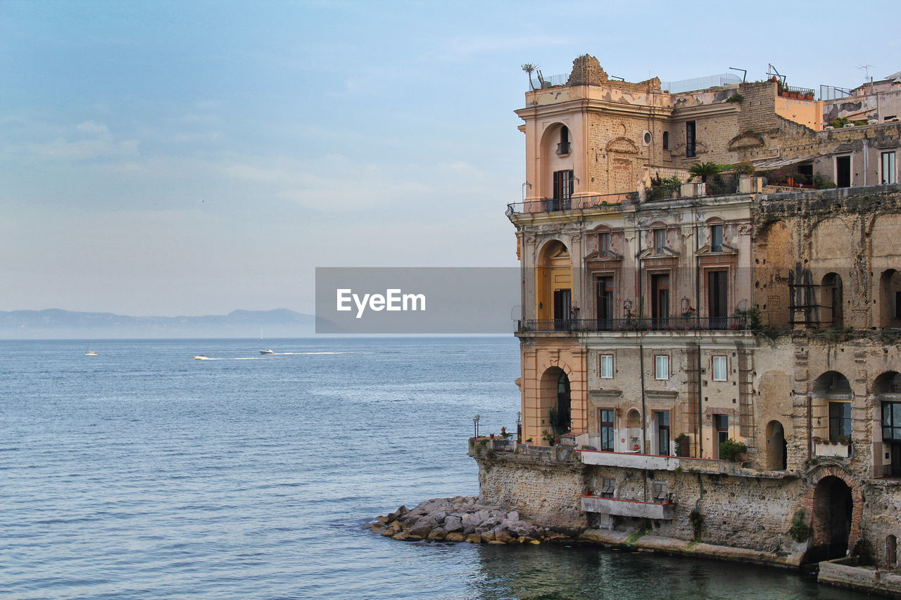 View of building by sea against sky