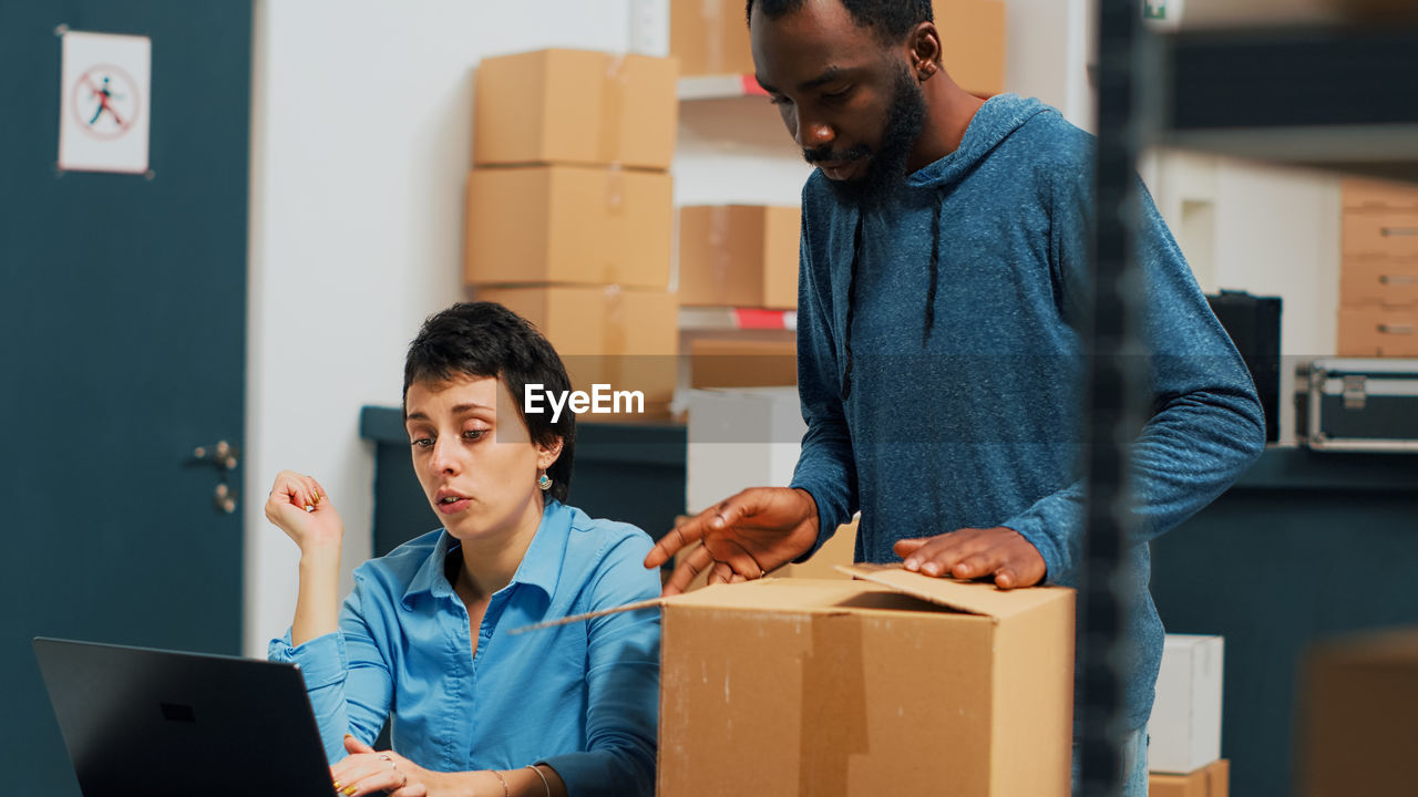 side view of man using digital tablet while sitting on table