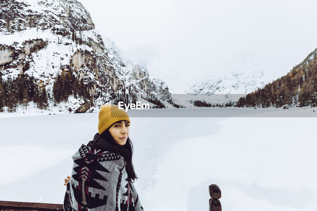 Portrait of woman sitting against snow covered land