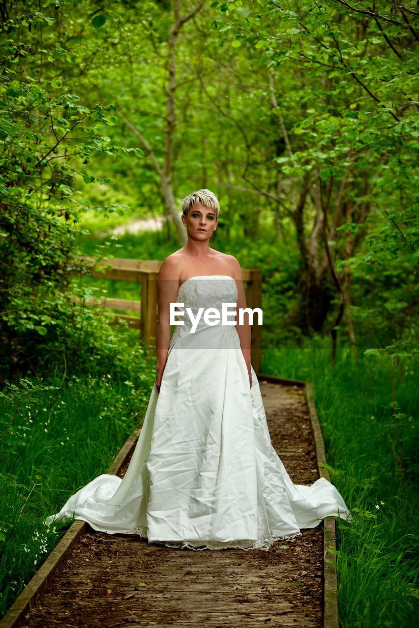 Portrait of bride standing on footpath in forest