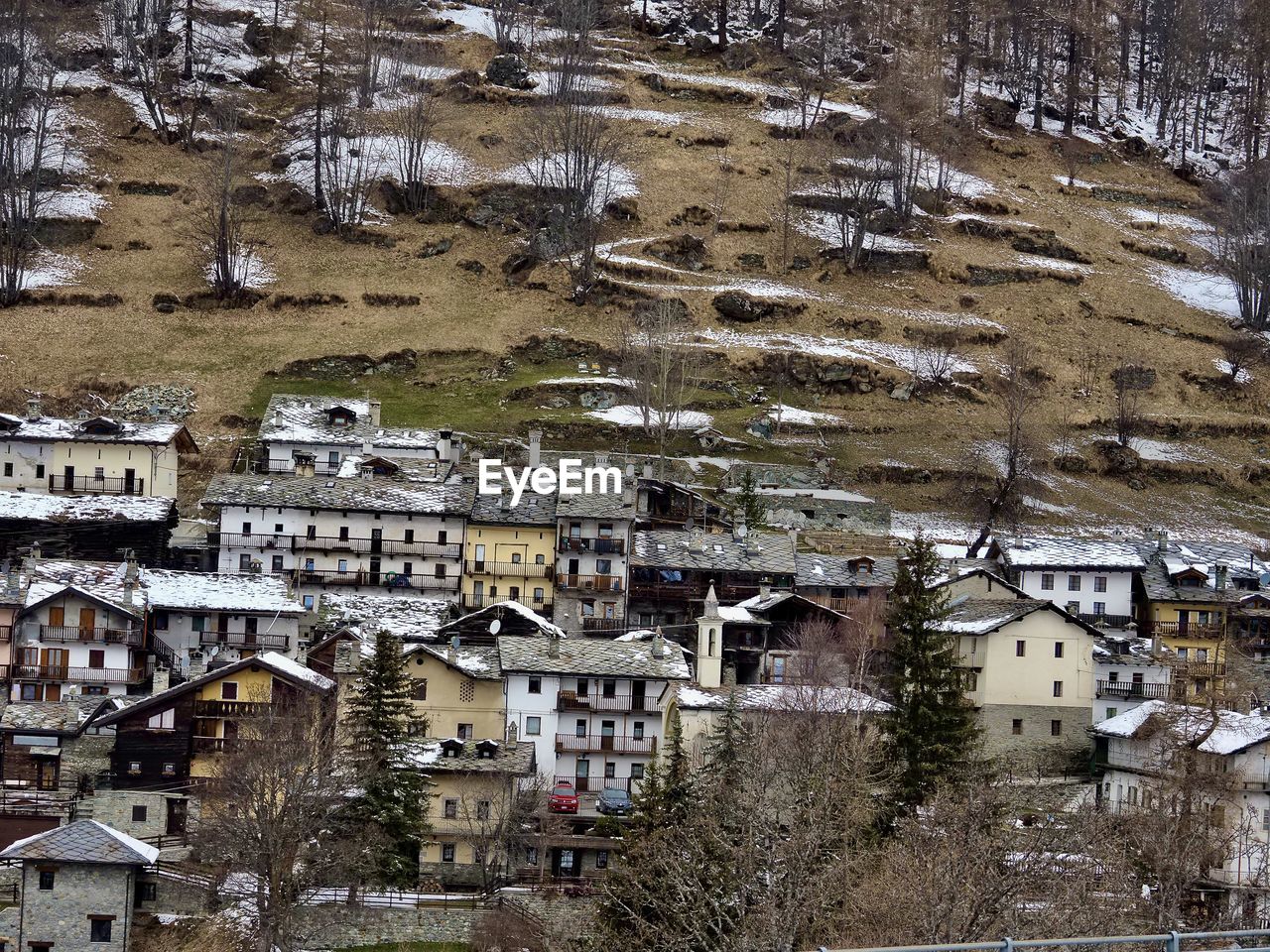 architecture, building exterior, built structure, building, town, high angle view, snow, residential district, aerial photography, no people, city, residential area, house, day, nature, tree, winter, cold temperature, plant, village, outdoors, suburb, roof, land, neighbourhood, mountain, cityscape, urban area, ancient history