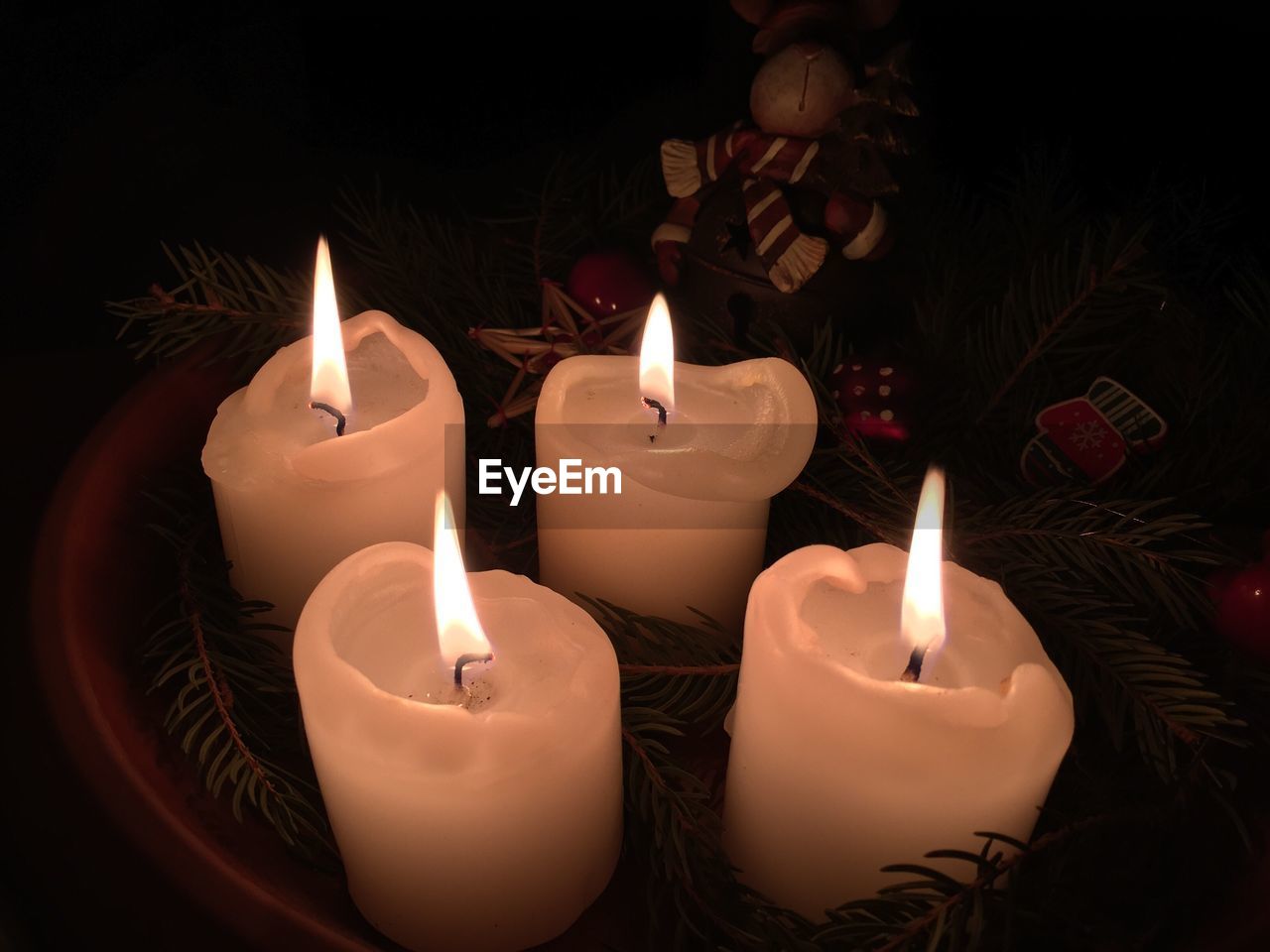 Close-up of lit candles and christmas decorations