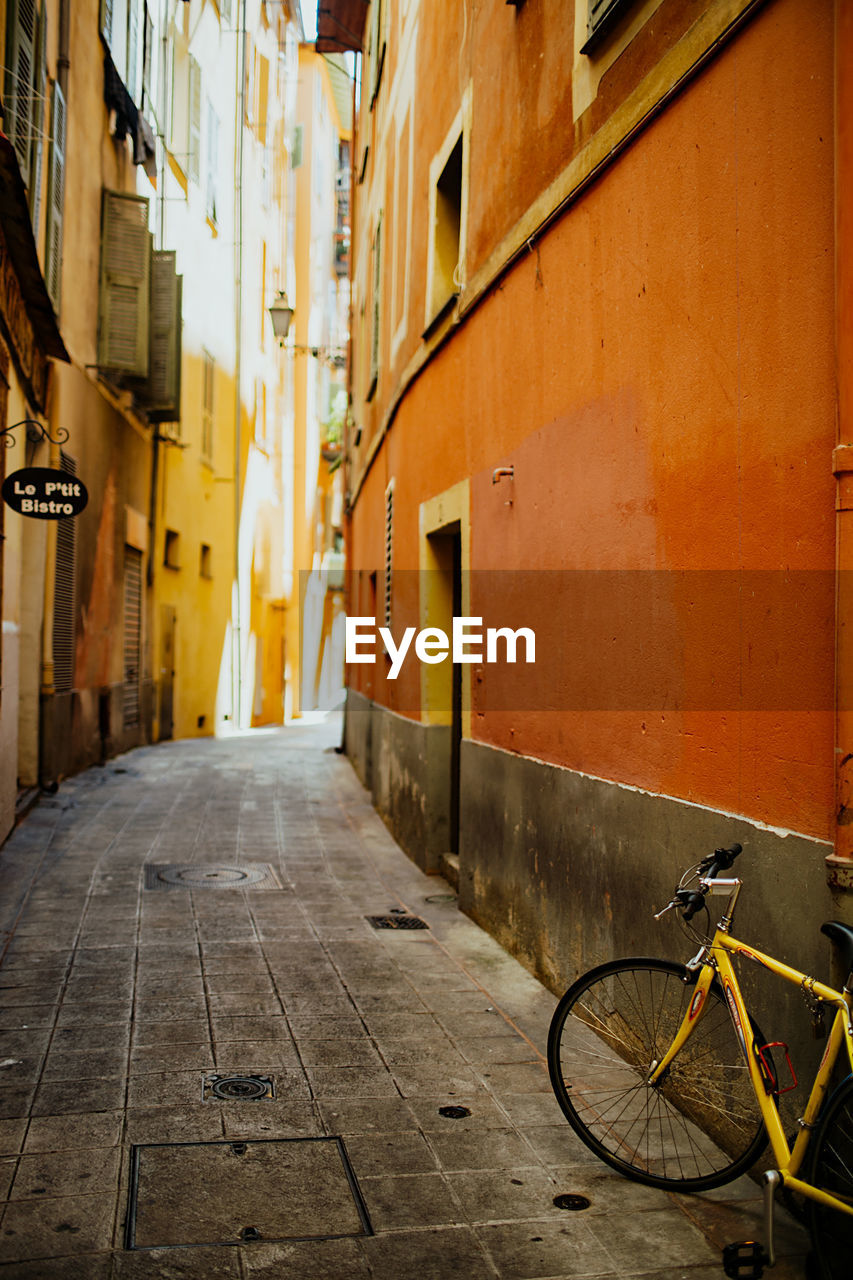 Bicycle parked on street amidst buildings