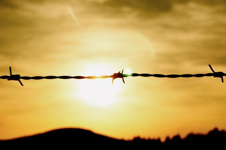 BARBED WIRE FENCE AT SUNSET