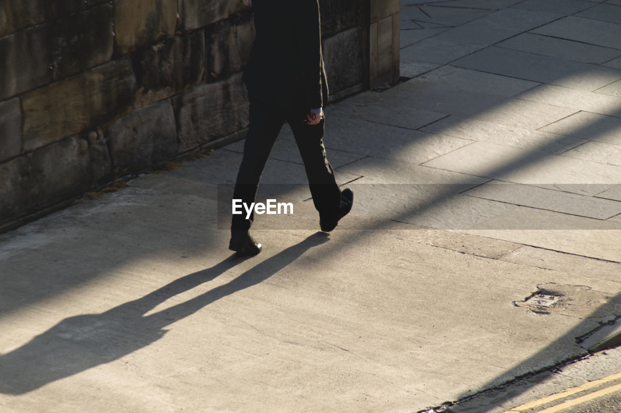 Low section of person walking on street