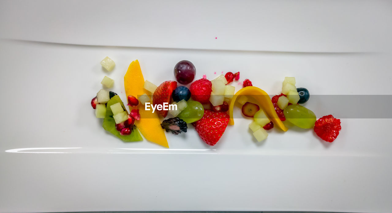 HIGH ANGLE VIEW OF MULTI COLORED FRUITS IN PLATE