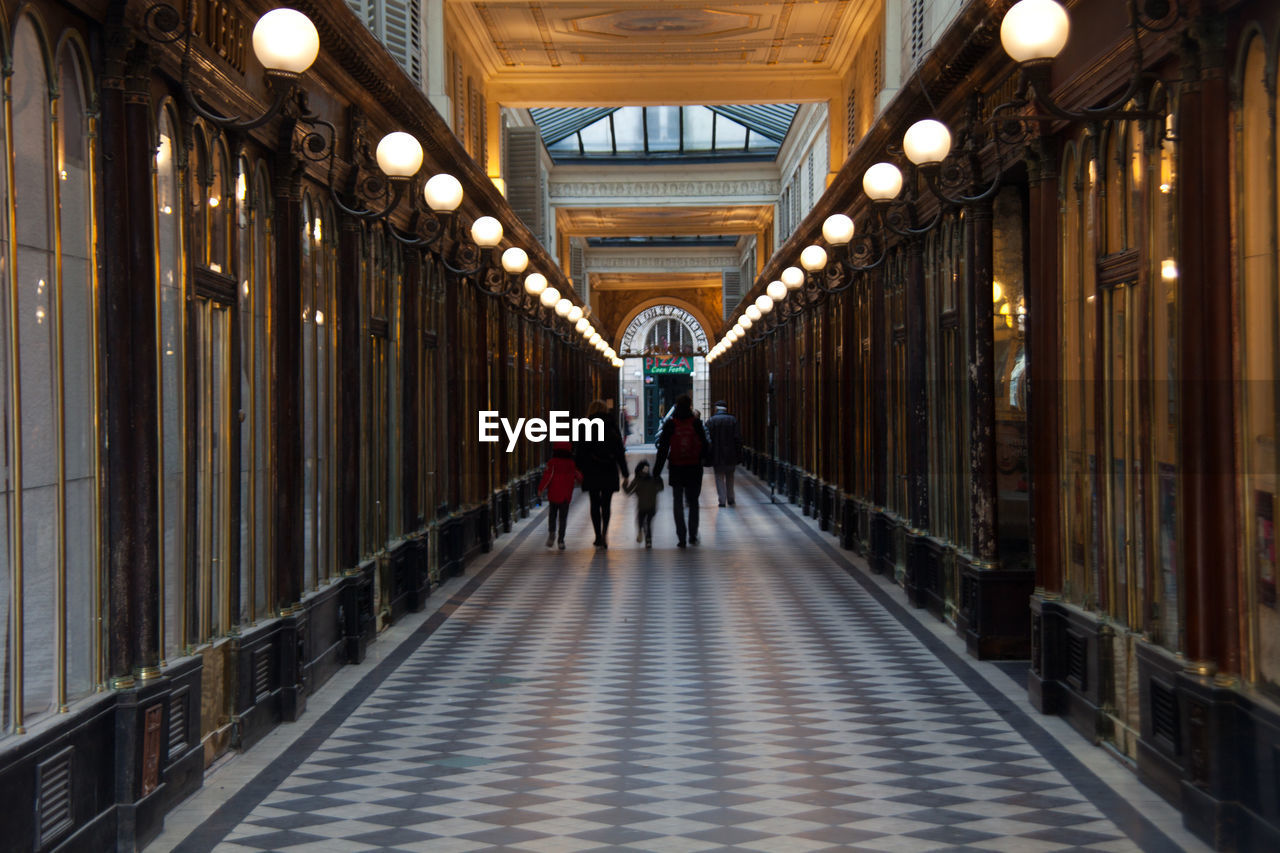 People walking through an illuminated corridor