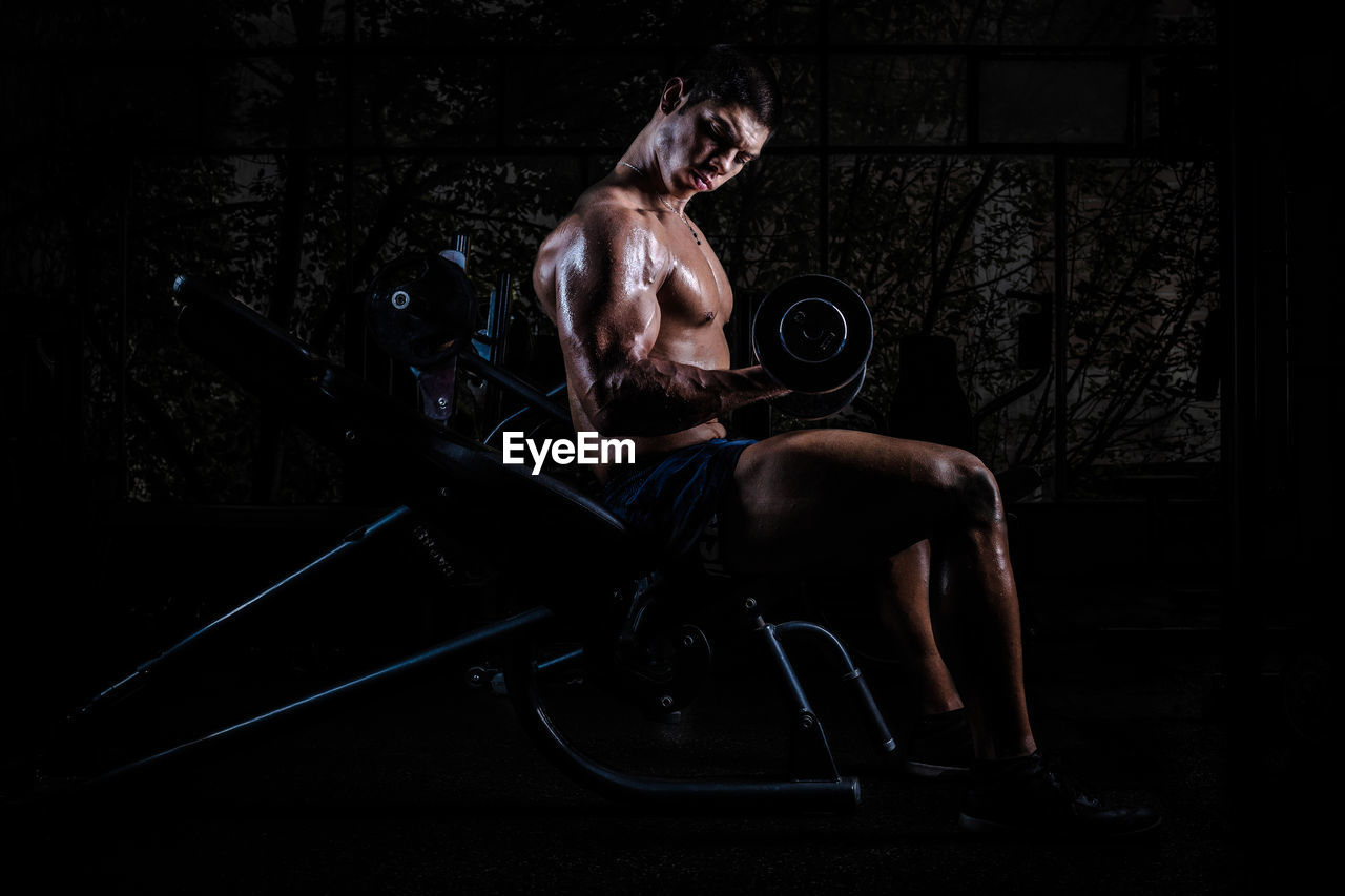 Shirtless muscular man exercising in gym