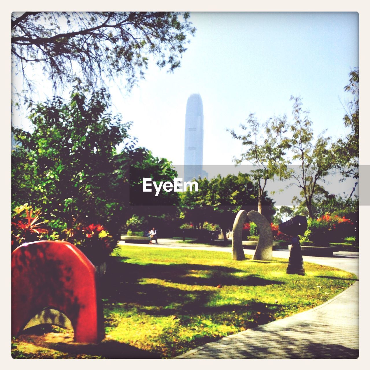 Trees in park with skyscraper in background