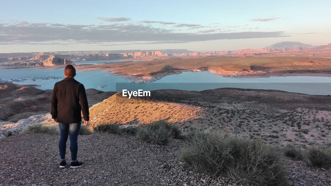 Full length rear view of man standing against lake powell