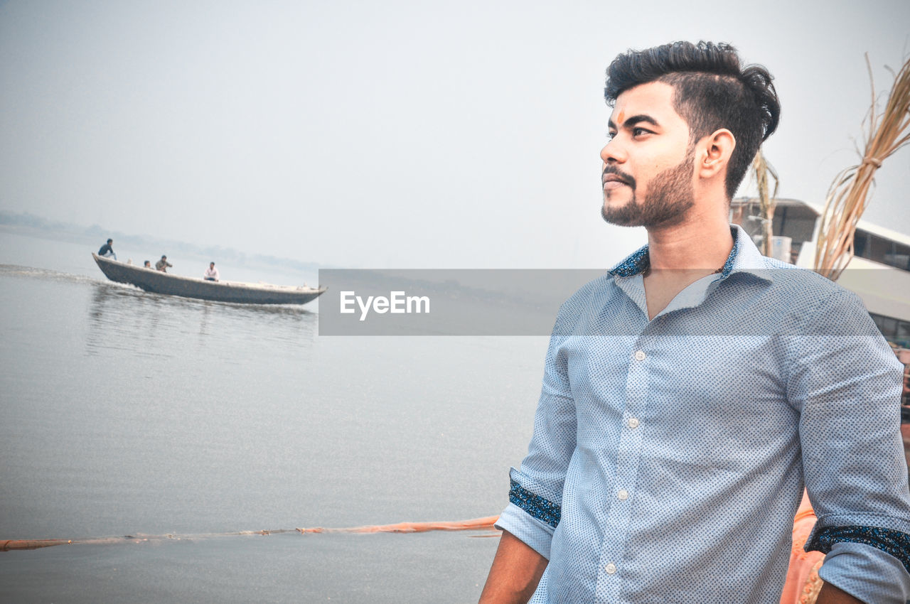 Young man looking away in sea