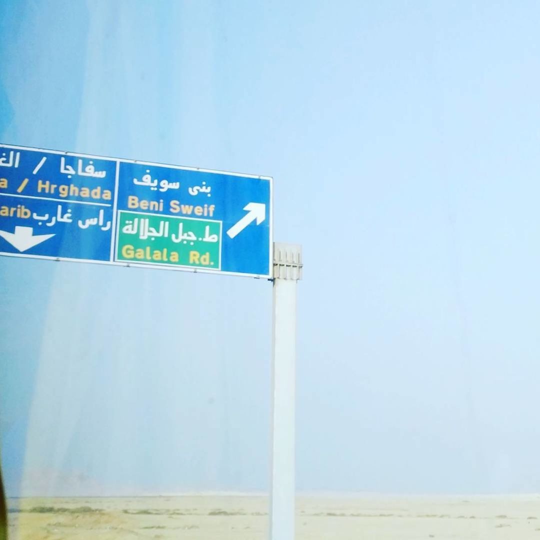 LOW ANGLE VIEW OF INFORMATION SIGN AGAINST CLEAR BLUE SKY AND