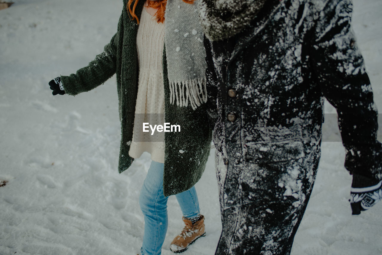 Low section of woman standing on snow covered land