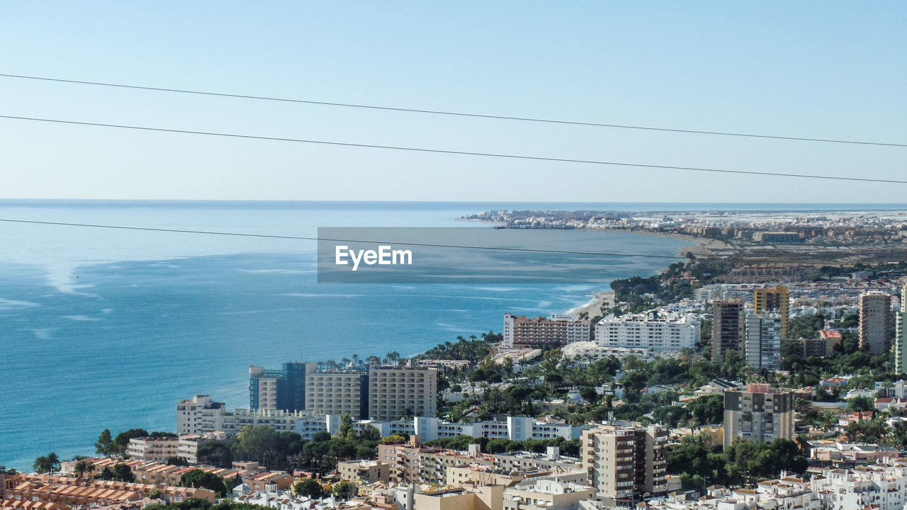 High angle view of buildings by sea against sky