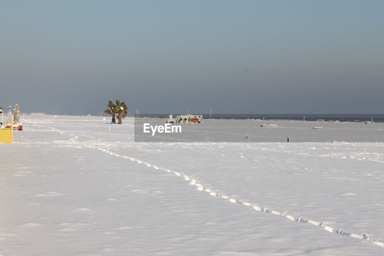 Scenic view of snow covered beach against sky during winter