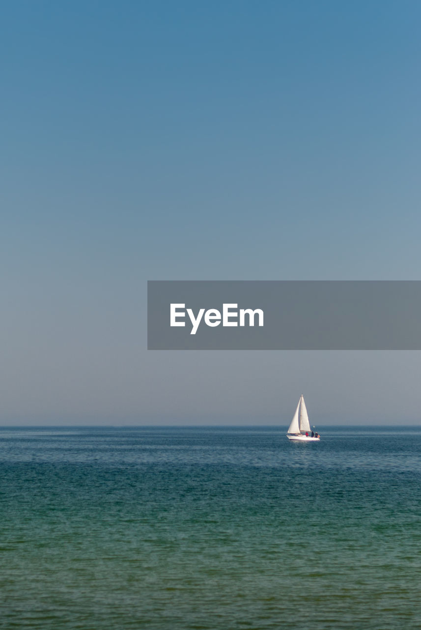 SAILBOAT SAILING ON SEA AGAINST CLEAR BLUE SKY