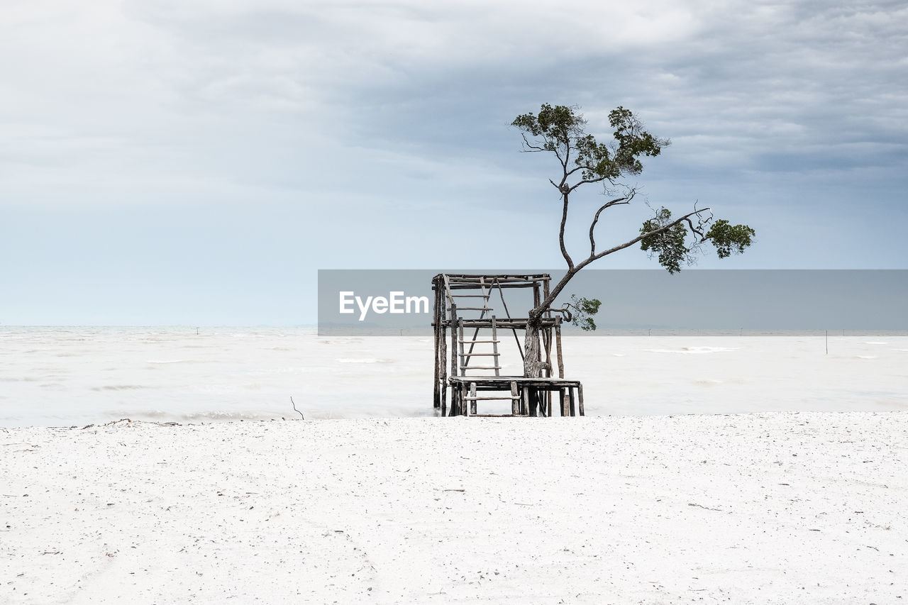 Lifeguard hut on beach against sky