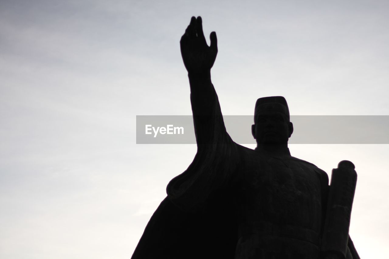 LOW ANGLE VIEW OF SILHOUETTE STATUE AGAINST SKY DURING SUNSET