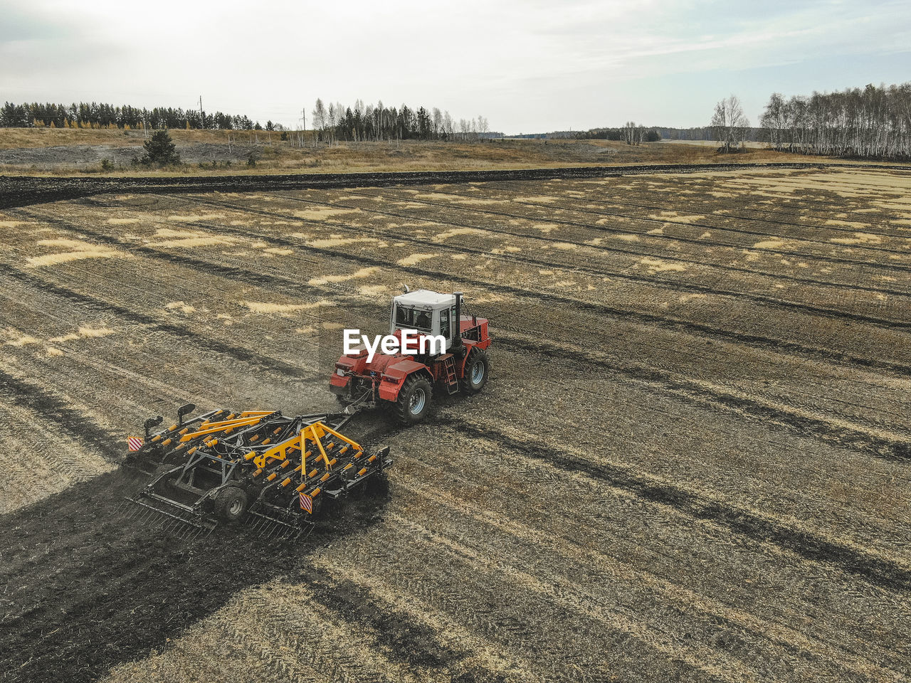 High angle view of tractor and agricultural equipment on field against sky